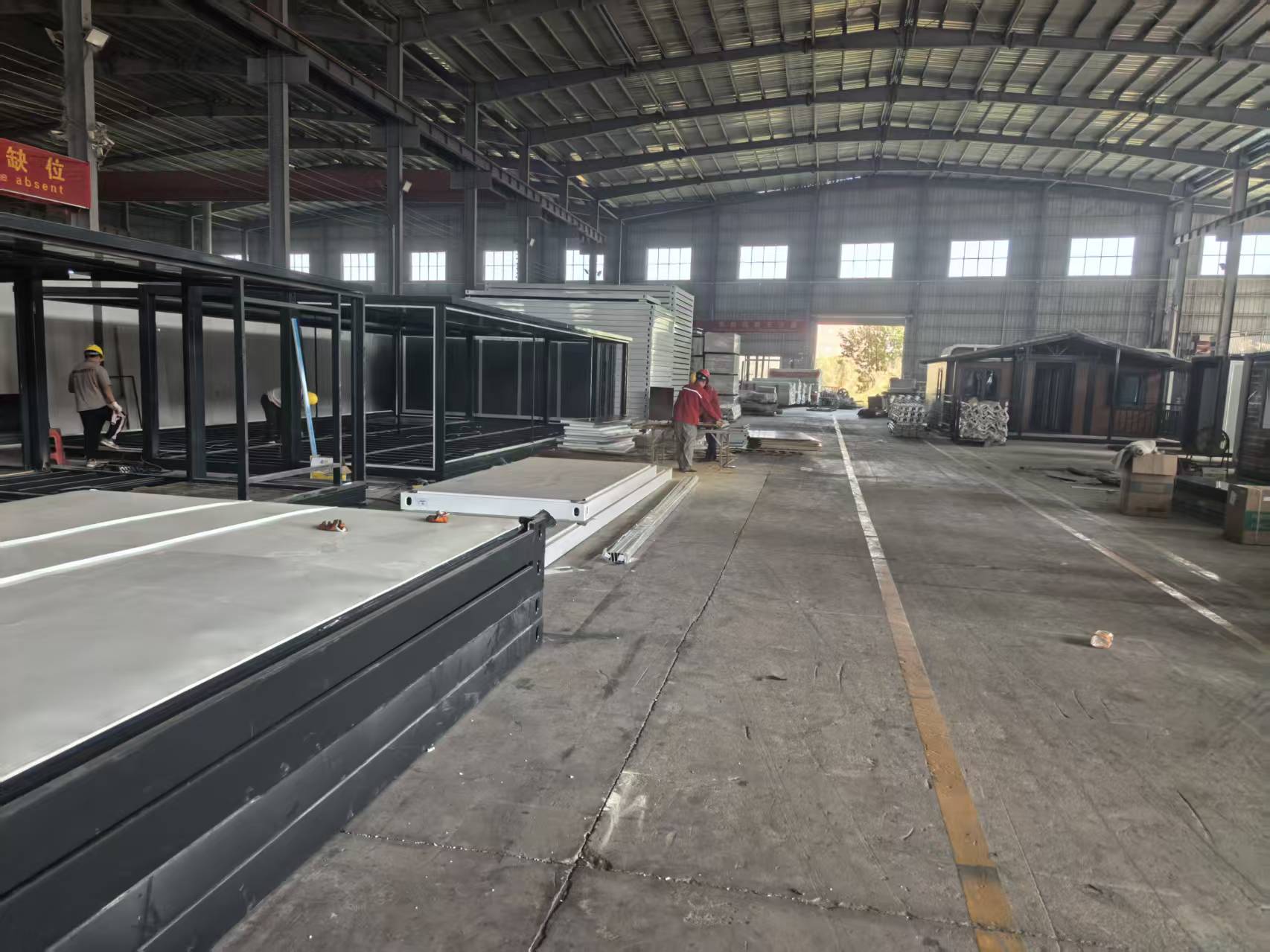 Automated production facility showing structural steel fabrication for expandable container houses