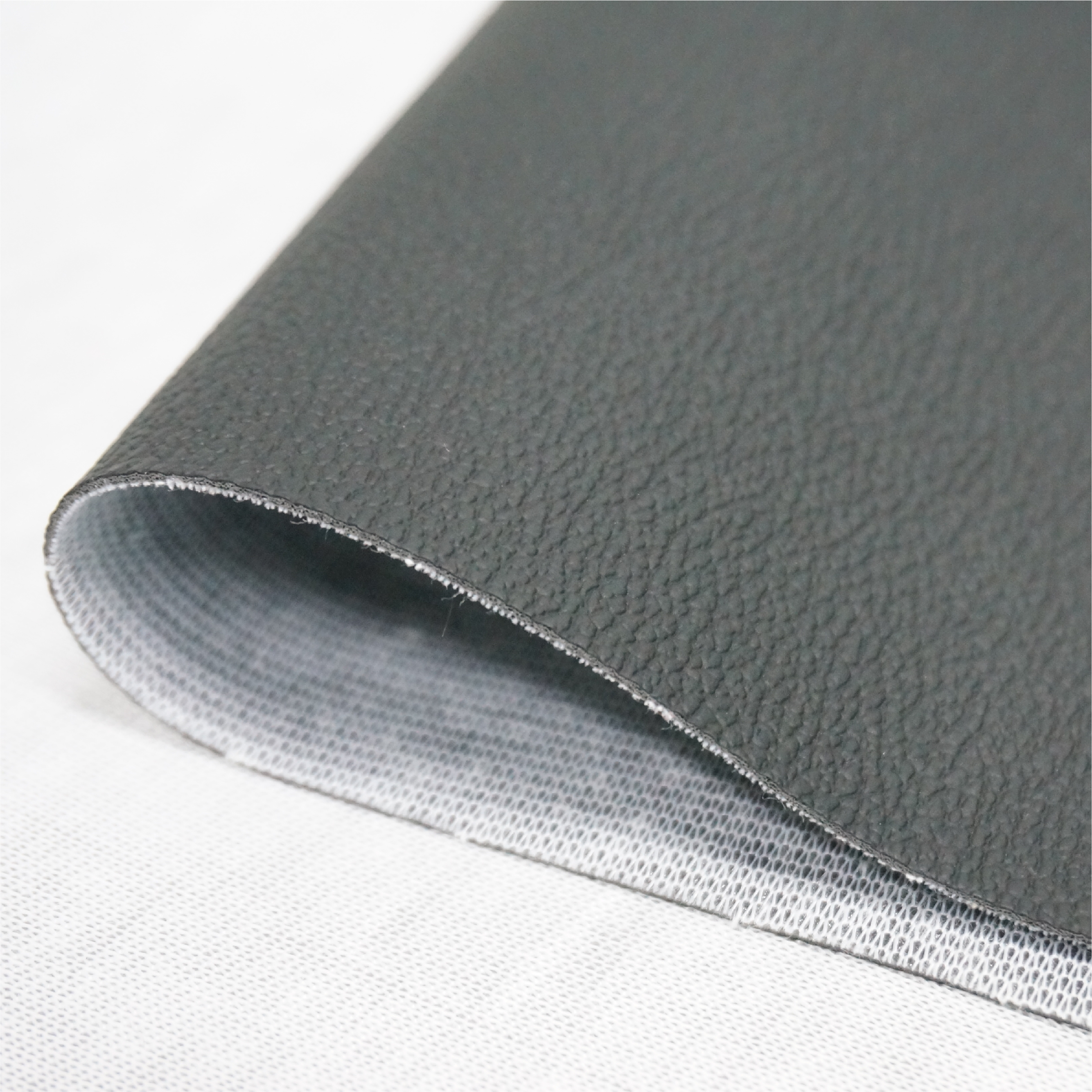 Synthetic leather material for car seat covers showing texture and backing structure