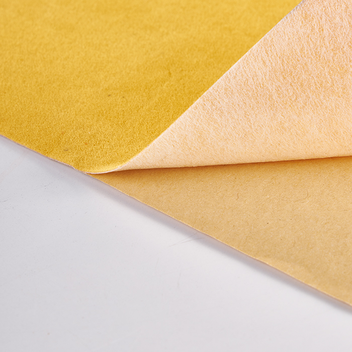 Detail view of the adhesive backing layer on self-adhesive flocking fabric.