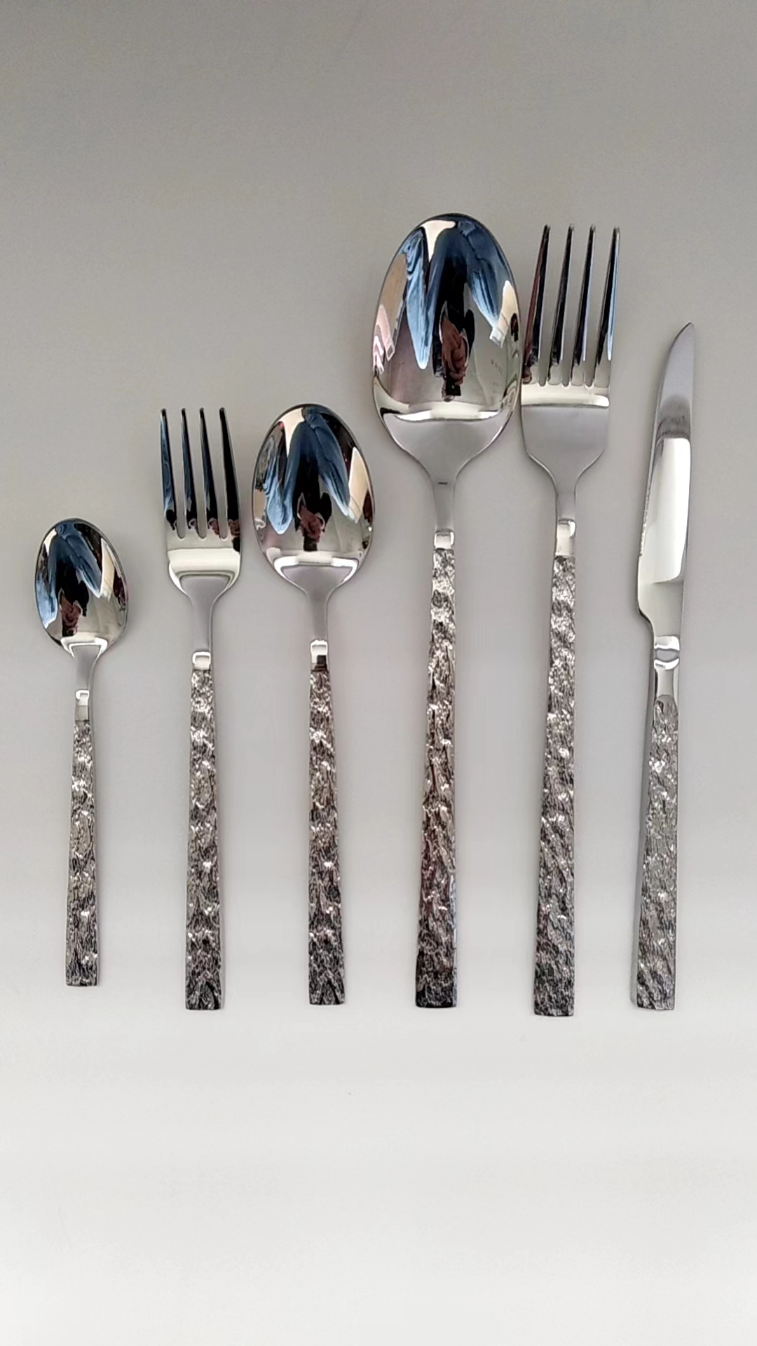 Close view of stone texture stainless steel flatware handle and polished metal surface